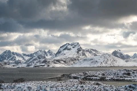 Sharp peaks and snowy ridges rise over a blue fjord on the Lofoten Islands,.. 写真素材