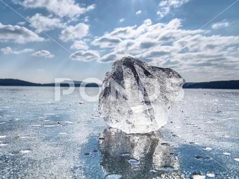 Sharp piece of ice. A symbol of harsh winter. The rays of the sun form rainbo Stock Photos