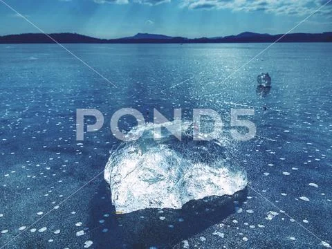 Sharp piece of ice. A symbol of harsh winter. The rays of the sun form rainbo Stock Photos