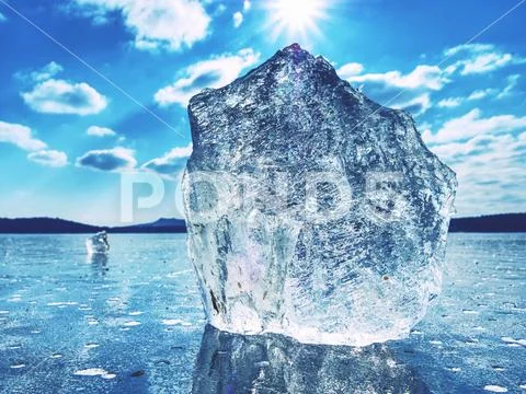 Sharp piece of ice. A symbol of harsh winter. The rays of the sun form rainbo Stock Photos