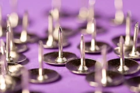 Sharp push pins on violet background Stock Photos