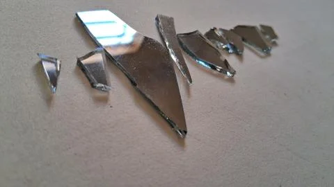 Sharp reflective shards of a broken mirror lying on surface Stock Photos
