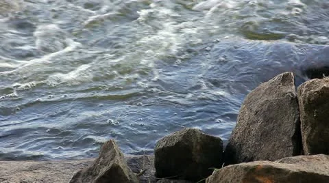 Sharp rocks on the riverbank with swift flowing water Stock Footage 11058726