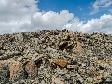 Sharp rocks on the slope. Background with a stone slope against a cloudy b... Stock Photos