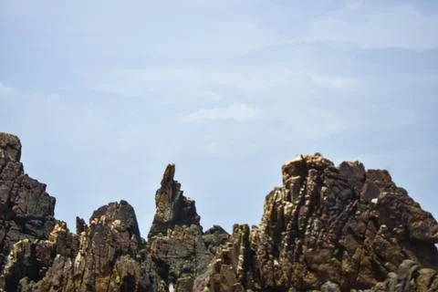 Sharp Rugged Sea Cliffs and Rocky Ridge Formations Under Clear Blue Sky Scenic 库存照片