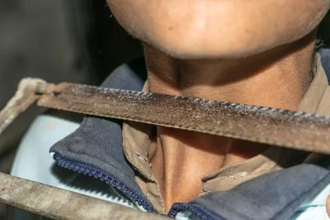 A sharp saw is kept on the neck of a child Stock Photos