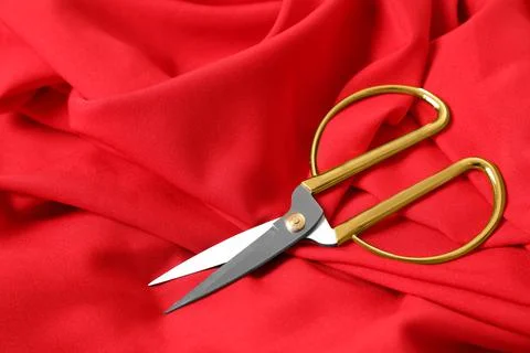 Sharp scissors on red fabric, space for text. Tailoring accessory Stockfoto's