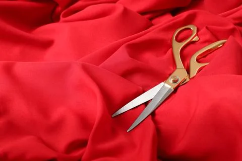 Sharp scissors on red fabric, space for text. Tailoring accessory Stock Photos