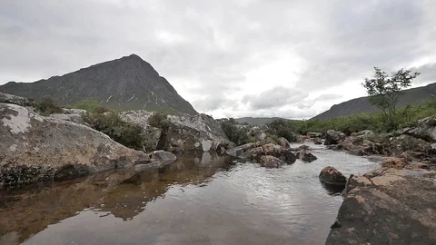 Sharp Scottish Hill on a Cloudy Day with Small River Water in the Foreground 스톡 동영상 97362052