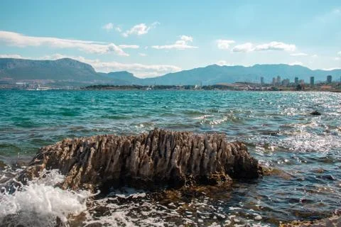 Sharp serrated rock standing surrounded by sea. Shaped by time and sea waves, Stock Photos