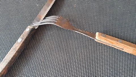Sharp serrated steak knife and metal fork with wooden handles Stock Photos