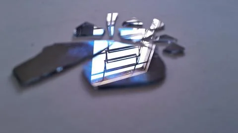 Sharp shards of a broken mirror reflecting a bright window Stock Photos