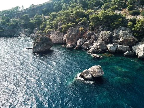 Sharp stones and rocks in the turquoise, blue sea. Drone aerial shot from above Stock Photos
