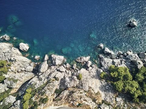 Sharp stones and rocks in the turquoise, blue sea. Drone aerial shot from above Stock Photos