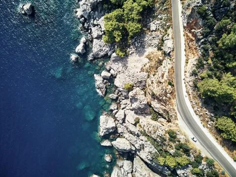 Sharp stones and rocks in the turquoise, blue sea. Drone aerial shot from above Stock Photos