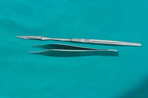 A sharp surgical blade on green table in operating room Foto stock