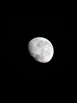 Sharp telescopic image of the brightly shining moon on a clear summer night Stock Photos