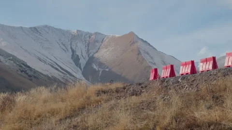 Sharp turn on mountain road. Red safety barriers. Scenic mountains in winter Stock Footage 267216540