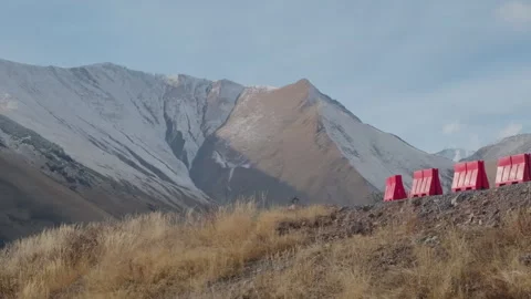 Sharp turn on mountain road. Red safety barriers. Scenic mountains in winter Stock Footage 267216852