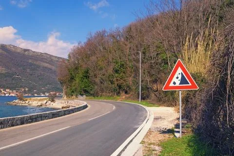 Sharp turn of the road with a warning road sign of falling stones. Montenegro Stock Photos