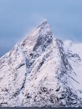 Sharp winter snowy mountain peak in Reine, Lofoten fjord Foto stock