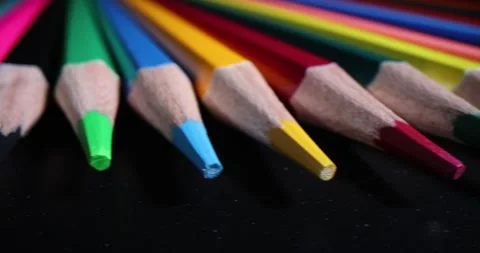 Sharp wooden multi-colored pencils on black background Stock Footage 260884592