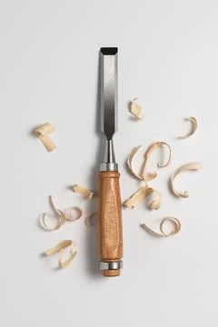 Sharp woodworking chisel with wooden handle surrounded by wood shavings on a  Stock Photos