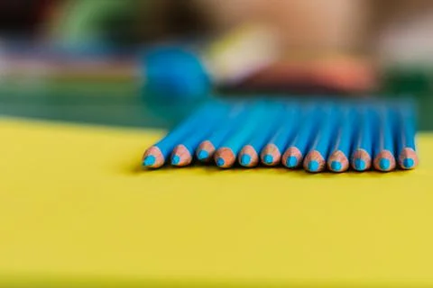 Sharpened blue pencils on a yellow background. Stock Photos