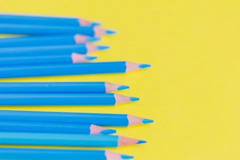 Sharpened blue pencils on a yellow background. Stock Photos