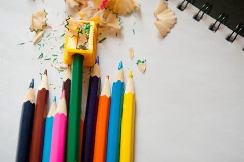 Sharpened colored pencils, sharpener and shavings Stock Photos