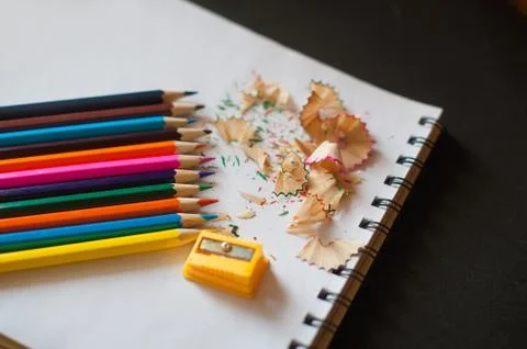Sharpened colored pencils, sharpener and shavings Stock Photos
