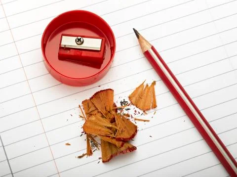 Sharpened pencil next to the sharpener and shavings. Stock Photos