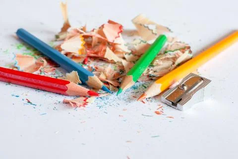 Sharpener and four crayons on a scrap of sharpening Stock Photos