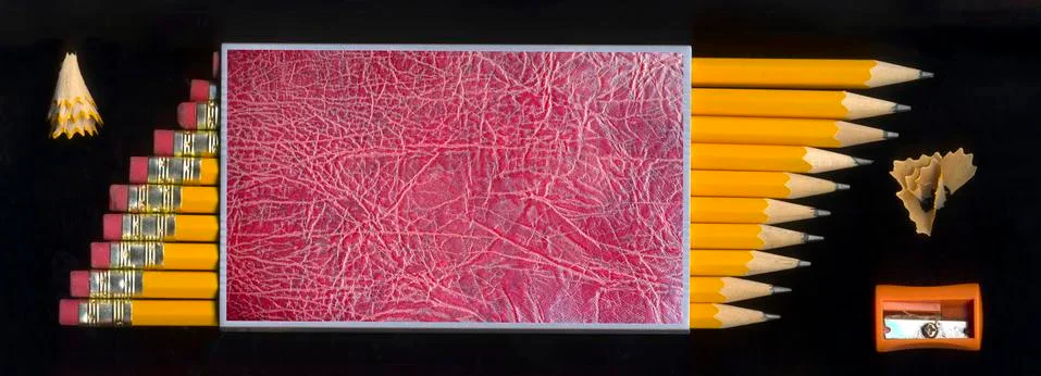 Sharpener and some sharp black pencils with pencil peels Stock Photos