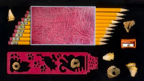 Sharpener and some sharp black pencils with pencil peels Stock Photos