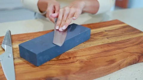 Sharpening Chefâs Knife on Whetstone in Kitchen Setting Video stock 314929016