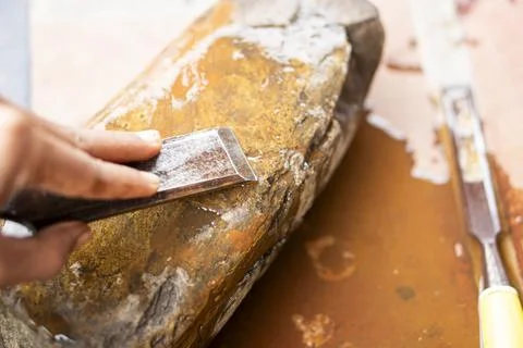 Sharpening a chisel on a wet stone Stock Photos