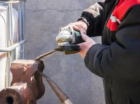 Sharpening garden tools hoe using grinder close-up, Machine for grinding / we Stock Photos