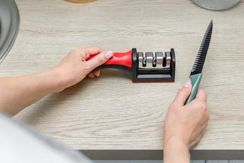Sharpening a kitchen knife in the home kitchen Stock Photos