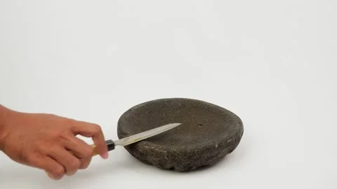 Sharpening Kitchen Knife on Traditional Stone Mortar Stock Footage 327850759