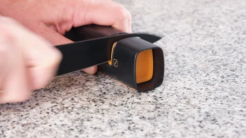 Sharpening a kitchen knife using a manual knife sharpener 스톡 동영상 341445012