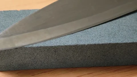 Sharpening Kitchen Knife With Water Whetstone On A Kitchen Table Video stock 322720022