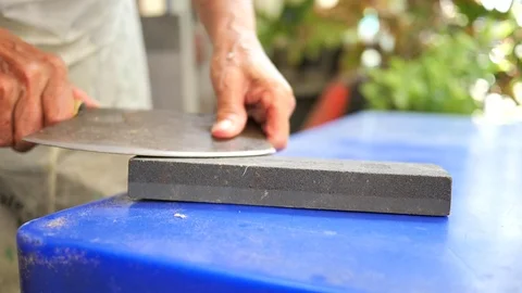 Sharpening the knife on Grind stone (Slow motion) Stock Footage 107512065