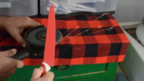 Sharpening a knife with a grinder Stock Footage 140804580