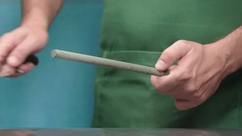 Sharpening the knife. Hands hold a knife and a sharpening tool. Vidéo 137464853