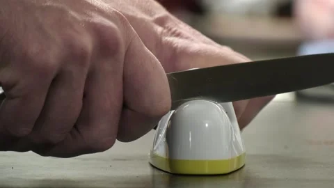 Sharpening a knife. A man sharpens a kitchen knife. Stock Footage 159674591