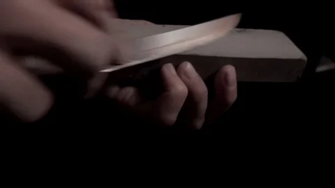 Sharpening a knife with a stone Stock Footage