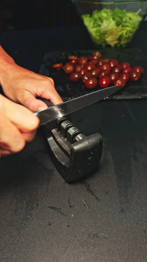Sharpening knife with tomatoes close-up Stock Footage 277104294