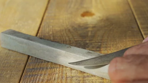 Sharpening the knife with whetstone Stock Footage 221184680