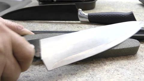 Sharpening a knife on a whetstone by hand. Stock Footage 149476555